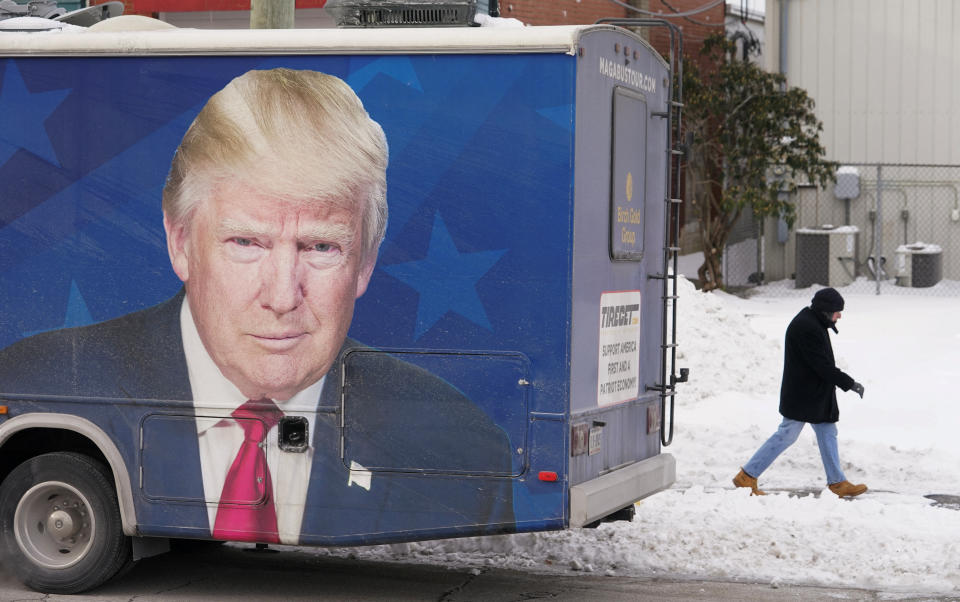 A man passes a bus parked outside Team Trump New Hampshire Headquarters ahead of the state's nominating contest in Manchester, New Hampshire, U.S., January 20, 2024. REUTERS/Kevin Lamarque