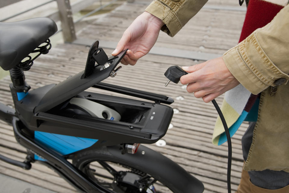 Une femme recharge son vélo électrique (photo Getty Images)