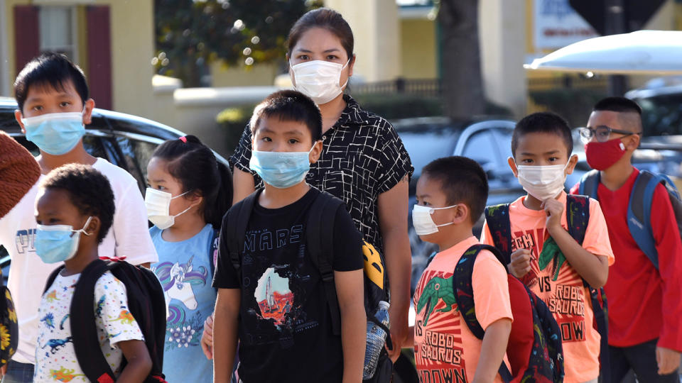 Students wearing face masks arrive on the first day of classes for the 2021-22 school year at Baldwin Park Elementary School in Orlando, Fla. 