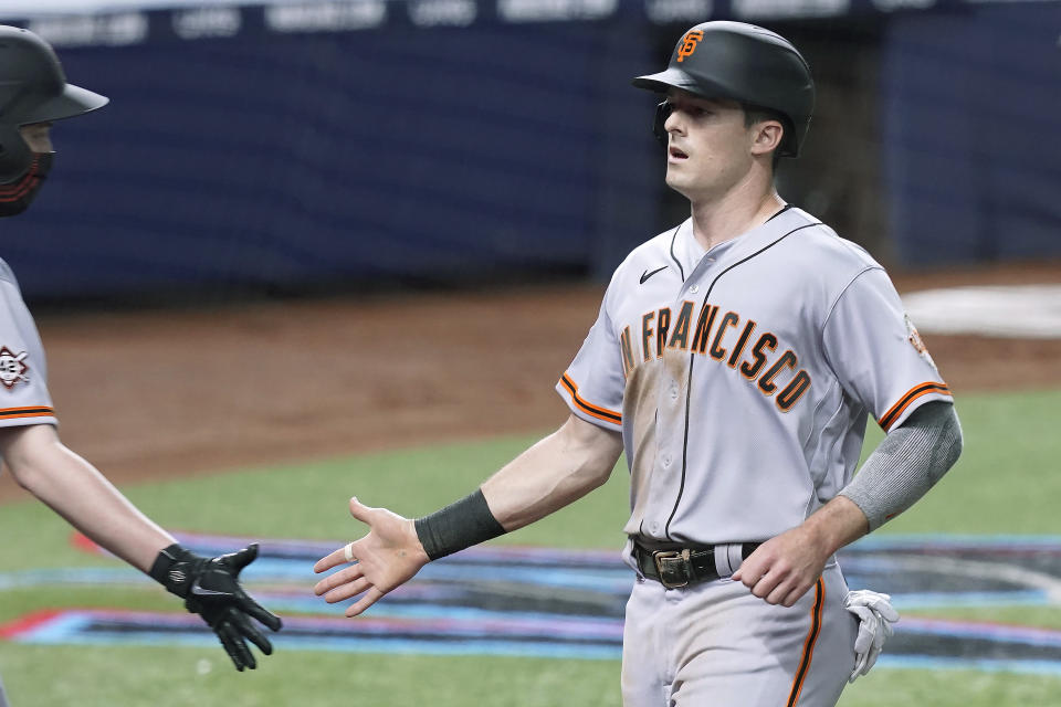 San Francisco Giants' Mike Yastrzemski (5) scores a run during the fourth inning of a baseball game against the Miami Marlins, Friday, April 16, 2021, in Miami. (AP Photo/Marta Lavandier)