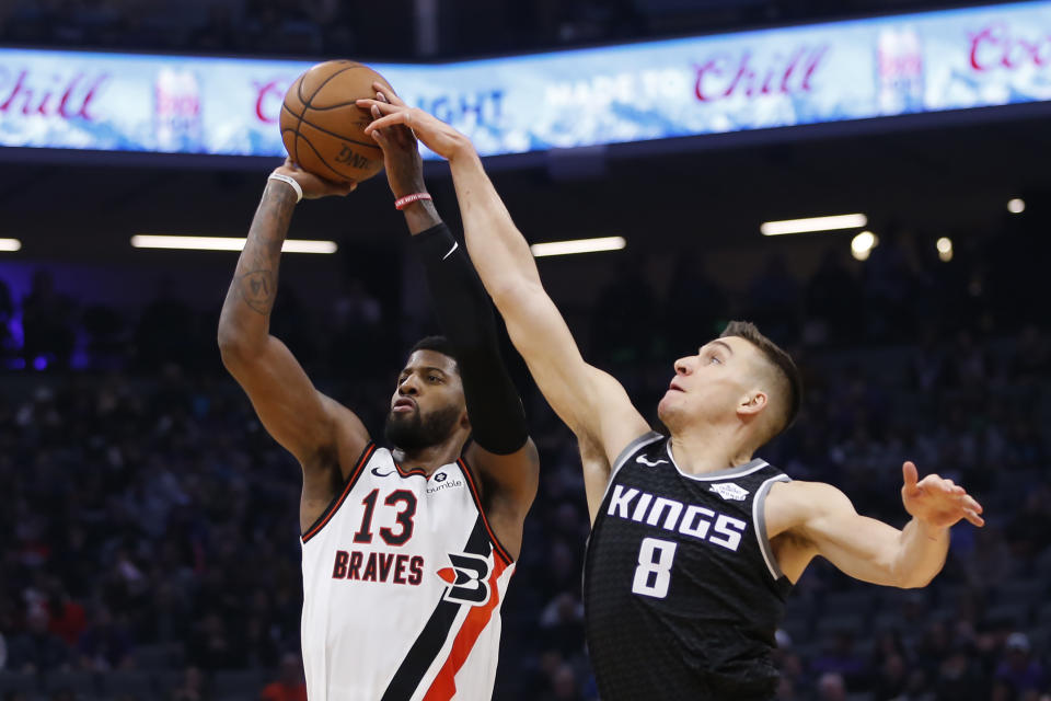 El escolta de los Kings de Sacramento Bogdan Bogdanovic bloquea el tiro del alero de los Clippers de Los Ángeles Paul George en la primera mitad del juego del martes 31 de diciembre de 2019, en Sacramento. (AP Foto/Rich Pedroncelli)