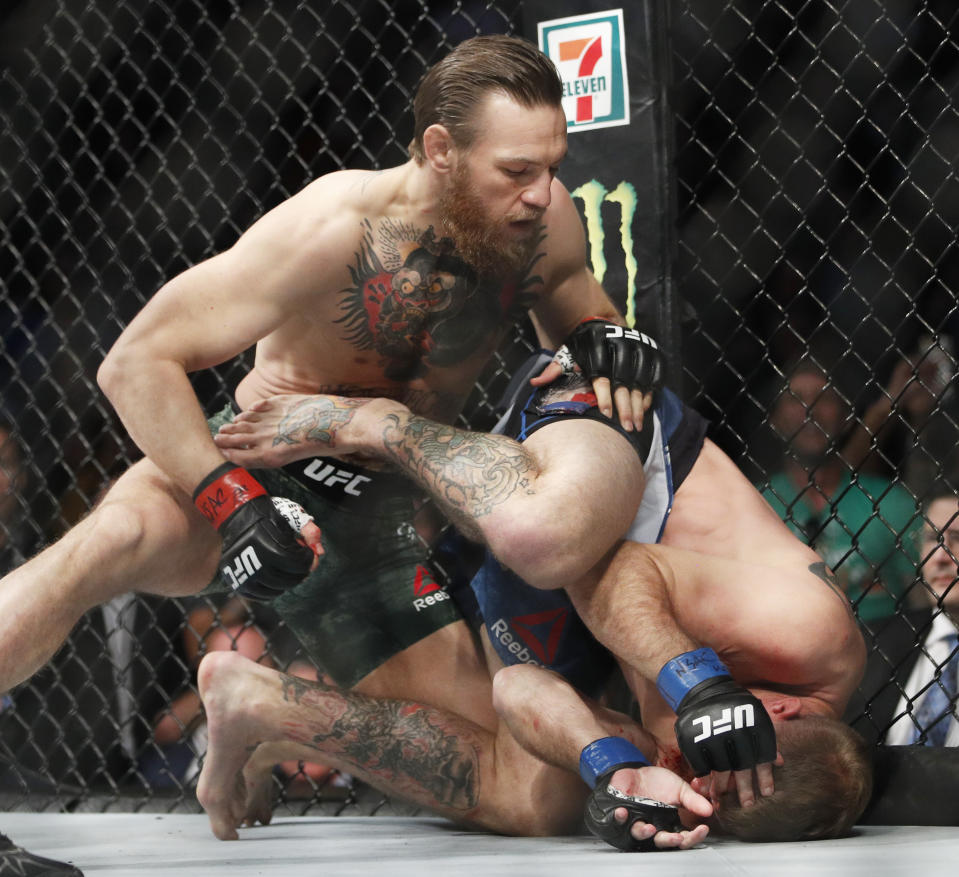 Conor McGregor, top, fights Donald "Cowboy" Cerrone during a UFC 246 welterweight mixed martial arts bout Saturday, Jan. 18, 2020, in Las Vegas. (AP Photo/John Locher)