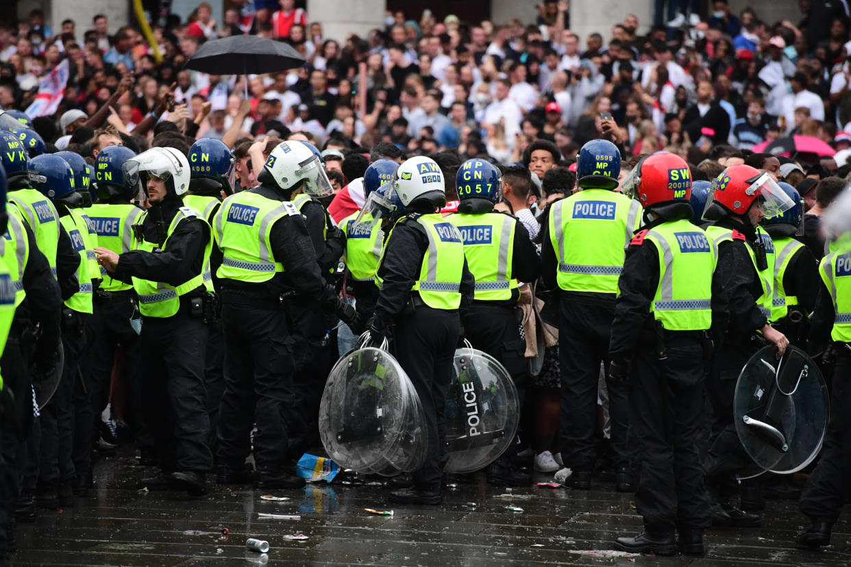 Police officers carry out riot shields to colleagues as they watch fans in Trafalgar Square, London during the UEFA Euro 2020 Final between Italy and England. Picture date: Sunday July 11, 2021.