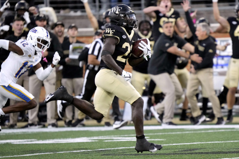 Wake Forest running back Demond Claiborne (23) runs for a touchdown past Pittsburgh defensive back M.J. Devonshire (12) during the second half of an NCAA college football game in Winston-Salem, N.C., Saturday, Oct. 21, 2023. (AP Photo/Chuck Burton)