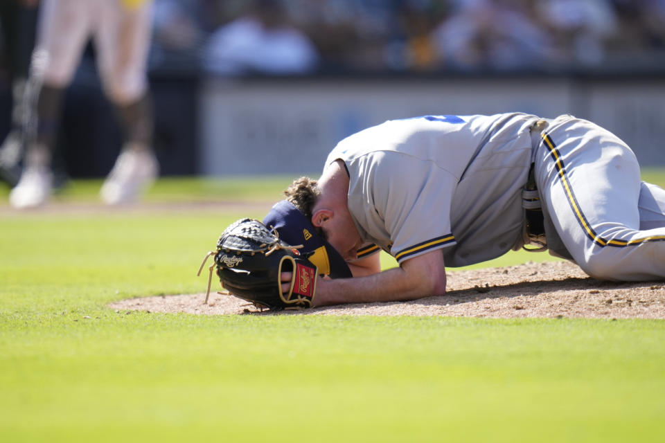 Milwaukee Brewers relief pitcher Gus Varland reacts after being hit by a comebacker from San Diego Padres' Manny Machado during the eighth inning of a baseball game Saturday, April 15, 2023, in San Diego. (AP Photo/Gregory Bull)