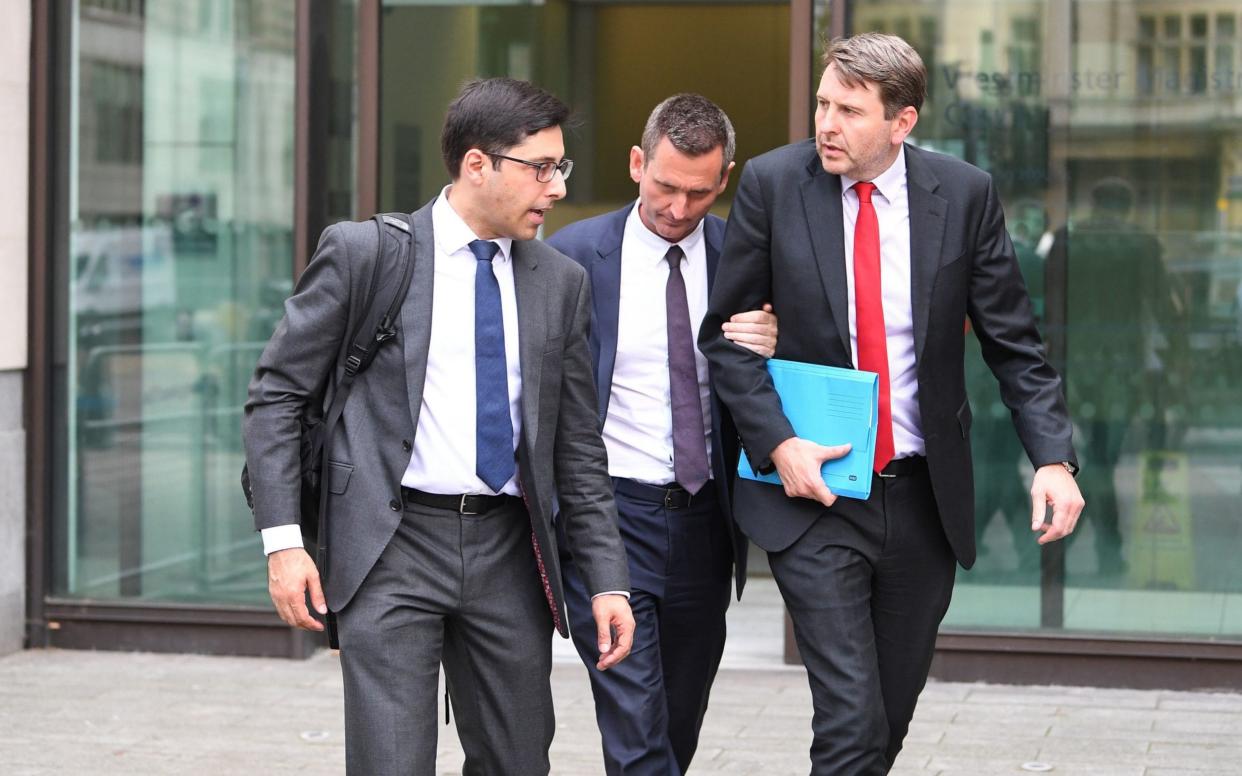 Lord Holmes of Richmond (centre) leaves Westminster Magistrates' Court, where he appeared on charges of sexual assault - PA