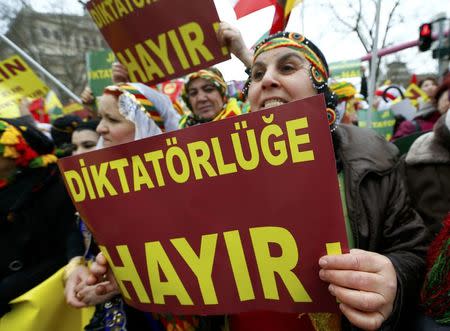 People hold placards with the slogan "Dictatorlie No" during a demonstration organised by Kurds, in Frankfurt, Germany, March 18, 2017. REUTERS/Ralph Orlowski