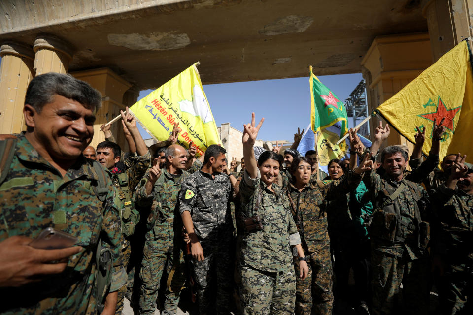 Fighters of Syrian Democratic Forces gesture the 