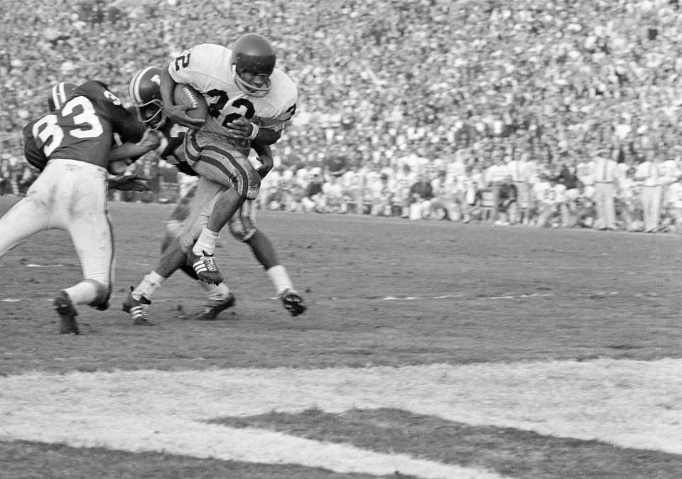 USC's O.J. Simpson squeezes between two Indiana defenders as he powered his way for his team's second touchdown on a blast through the line in the Rose Bowl in Pasadena, Calif., Jan. 1, 1968. Hoosiers are safety Mike Baughman, left, and halfback Nate Cunningham.