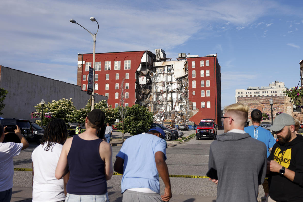 Onlookers watch as emergency crews work the scene of a partial building collapse Sunday on Main Street in Davenport, Iowa.  (Nikos Frazier / AP)