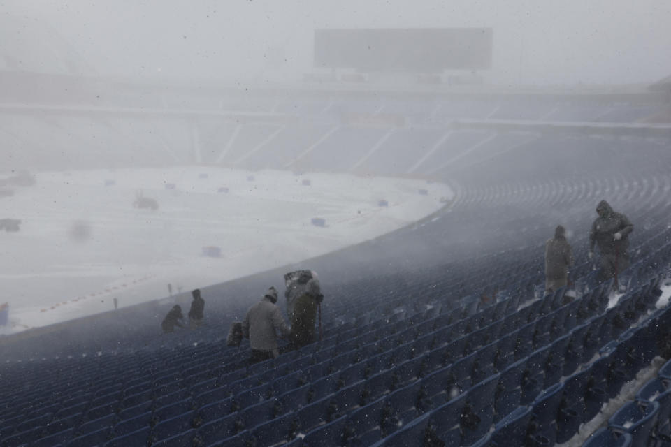 Workers remove snow from Highmark Stadium in Orchard Park, N.Y., Sunday Jan. 14, 2024. A potentially dangerous snowstorm that hit the Buffalo region on Saturday led the NFL to push back the Bills wild-card playoff game against the Pittsburgh Steelers from Sunday to Monday. New York Gov. Kathy Hochul and the NFL cited public safety concerns for the postponement, with up to 2 feet of snow projected to fall on the region over a 24- plus hour period. (AP Photo/ Jeffrey T. Barnes)