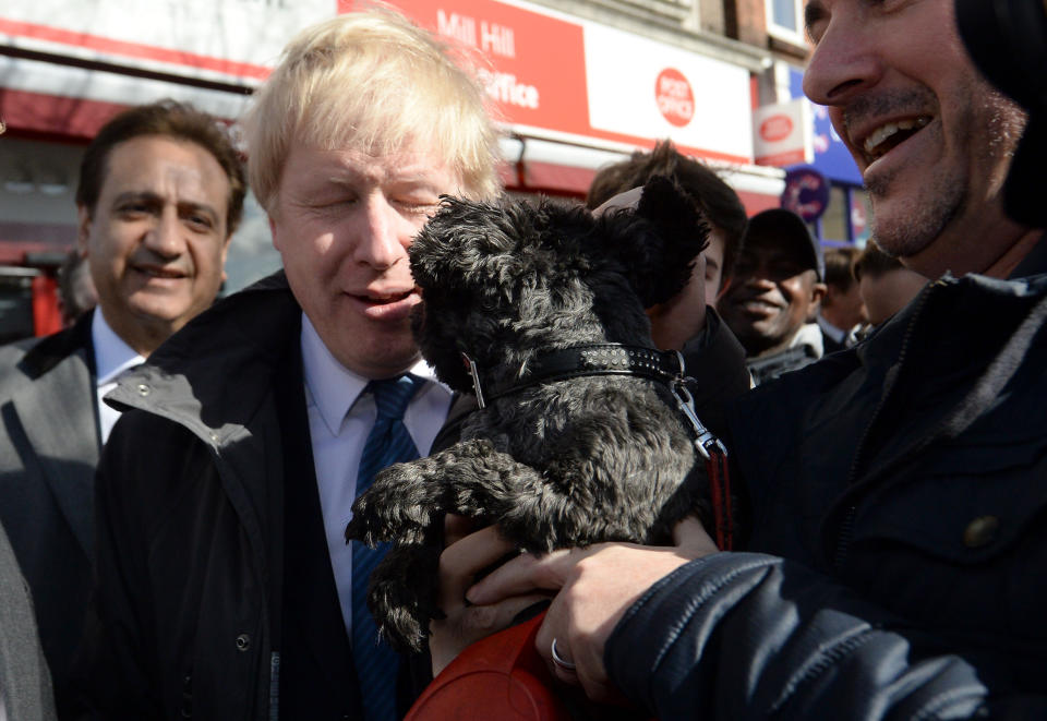 Mayor of London Boris Johnson is licked by a dog as he meets members of the public and local business owners after launching the Conservative London campaign at Hartley Hall in Mill Hill, London.