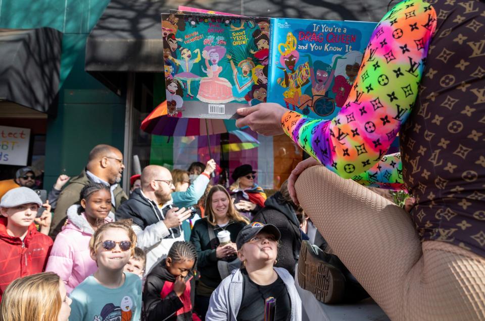 Over a dozen children stand together during an outdoor version of Drag Queen Story Time outside Sidetrack Bookshop in Royal Oak on Saturday, March 11, 2023.