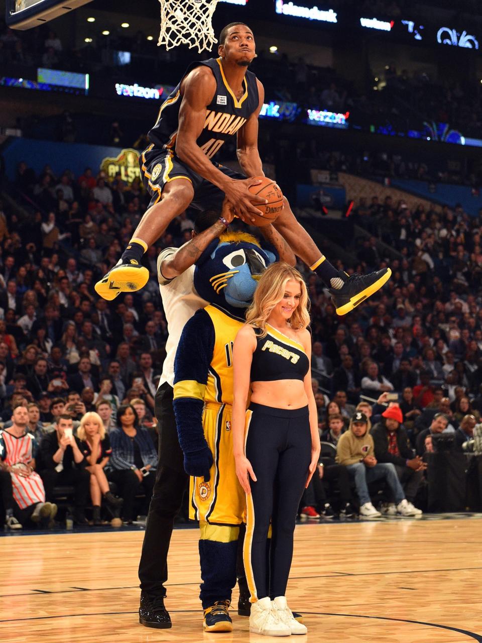 Indiana Pacers forward Glenn Robinson III leaps over teammate Paul George, mascot Boomer and Pacemate Kayla Noel to win this year's NBA dunk contest.