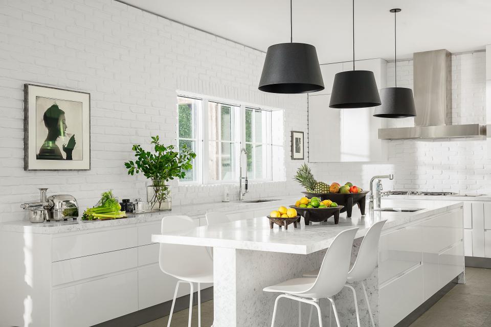 Pendants by Sean Lavin from Circa Lighting hang over the all-white kitchen; Miele appliances.