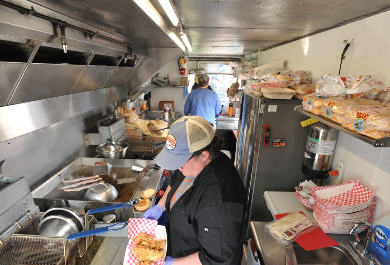 KC's Curbside Bistro owner Kerry Churchill of Rockland, foreground, prepares meals in her food truck during one of last year's Food Truck Tuesday events at Forge Pond Park in Hanover, She will be back again for the locations opening evening on Tuesday, May 7.