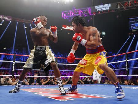 Manny Pacquiao of the Philippines (R) and Floyd Mayweather, Jr. of the U.S. fight in the seventh round during their welterweight WBO, WBC and WBA (Super) title fight in Las Vegas, Nevada, May 2, 2015. REUTERS/Steve Marcus