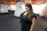 In this Friday, June 21, 2019, photo Ann Campeau, owner of Strut Bridal, stands in her shop in Tempe, Ariz. Cut-rate prices on websites that sell wedding dresses direct from China put pressure on Campeau, who owns four bridal shops in California and Arizona. She has had customers come in after seeing low-end gowns online and expecting to get a dress at a similar price. (AP Photo/Matt York)