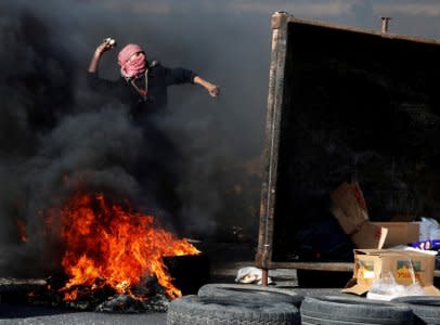 A Palestinian protester throws a stone at Israeli forces during a protest against U.S. President Donald Trump's decision to recognize Jerusalem as the capital of Israel, near the Jewish settlement of Beit El, near the West Bank city of Ramallah December 11, 2017. REUTERS/Goran Tomasevic