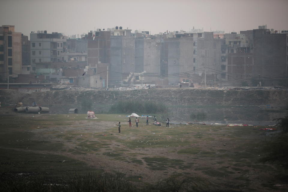 <p>Boys fly a kite as residential houses are seen shrouded in smog in New Delhi, India, November 15, 2021. REUTERS/Adnan Abidi REFILE-QUALITY REPEAT</p> 