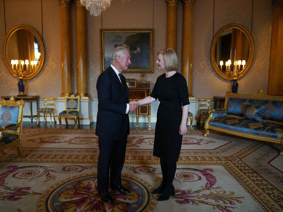 King Charles III and Liz Truss shake hands at Buckingham Palace.