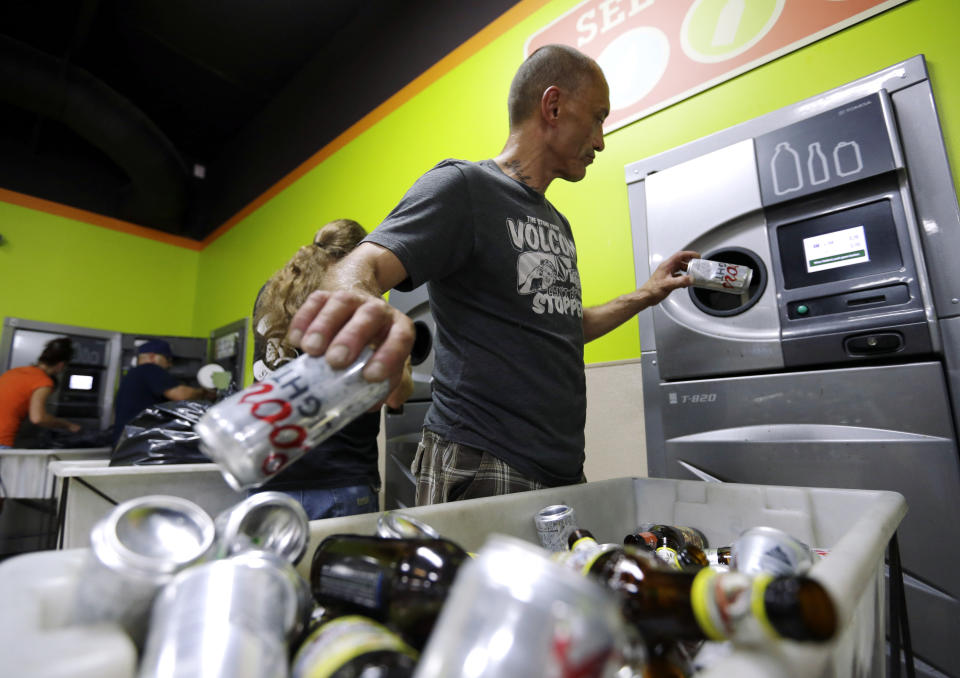 Many countries have introduced ‘reverse vending machines’ where people are paid to recycle their used bottles and cans (Don Ryan/AP)