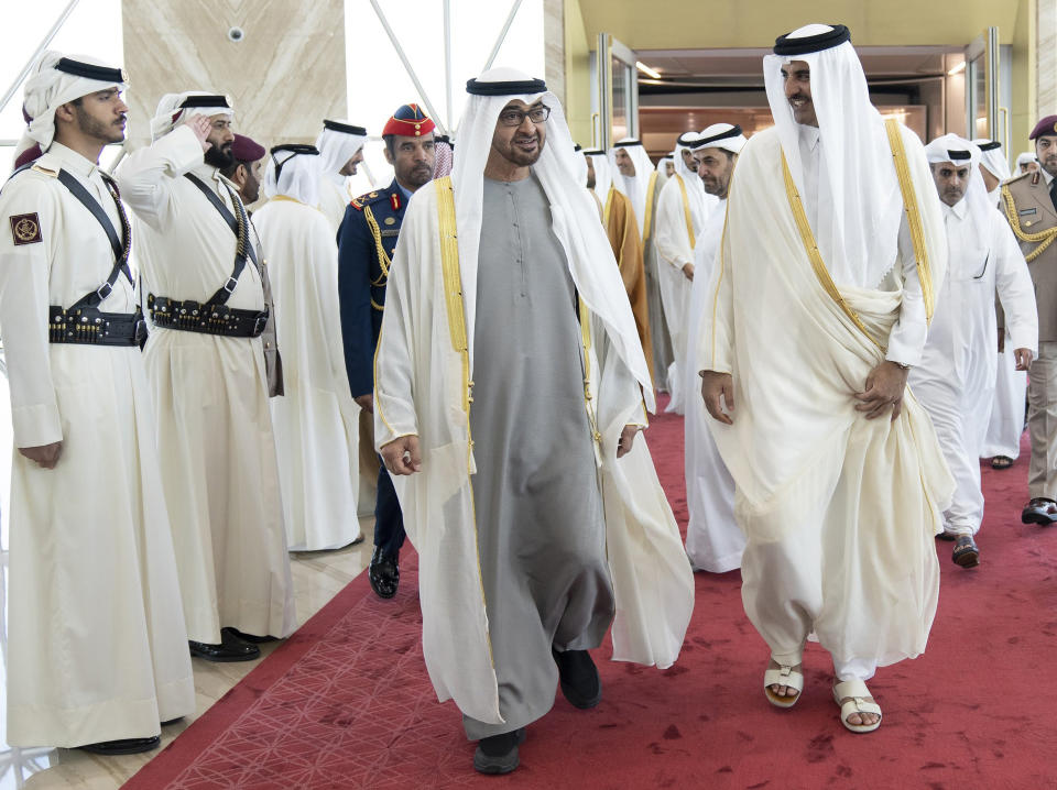 In this photo released by Qatar Amiri Diwan, Qatari Emir Sheikh Tamim bin Hamad Al-Thani, right, greats UAE president Sheikh Mohamed bin Zayed Al-Nahyan, upon his arrival at the Hamad airport in Doha, Qatar, Monday, Dec. 5, 2022. (Qatar Amiri Diwan via AP)