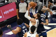 Memphis Grizzlies' Jonas Valanciunas, center, shoots past Minnesota Timberwolves' Karl-Anthony Towns (32) and Juancho Hernangomez (41) in the second half of an NBA basketball game, Wednesday, Jan. 13, 2021, in Minneapolis. The Grizzlies won 118-107. Valanciunas led the Grizzlies with 24 points. (AP Photo/Jim Mone)