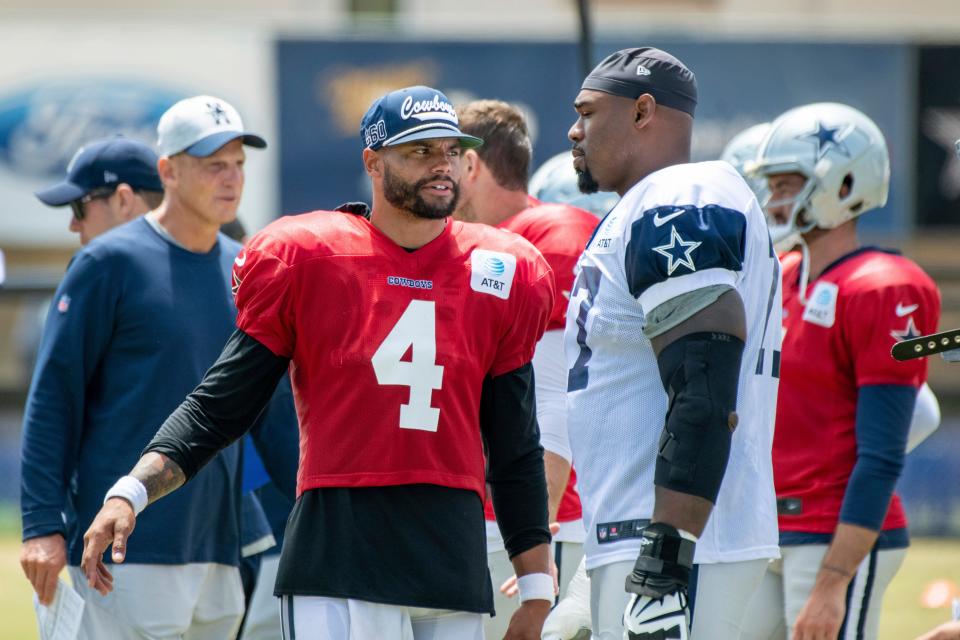 Dallas Cowboys quarterback Dak Prescott (4) talks with tackle Tyron Smith during practice at the NFL football team's training camp in Oxnard, Calif., Saturday, July 31, 2021.