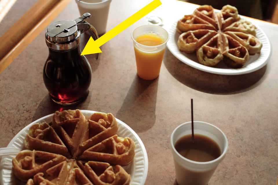 American breakfast in diner with waffles, orange juice, and syrup.