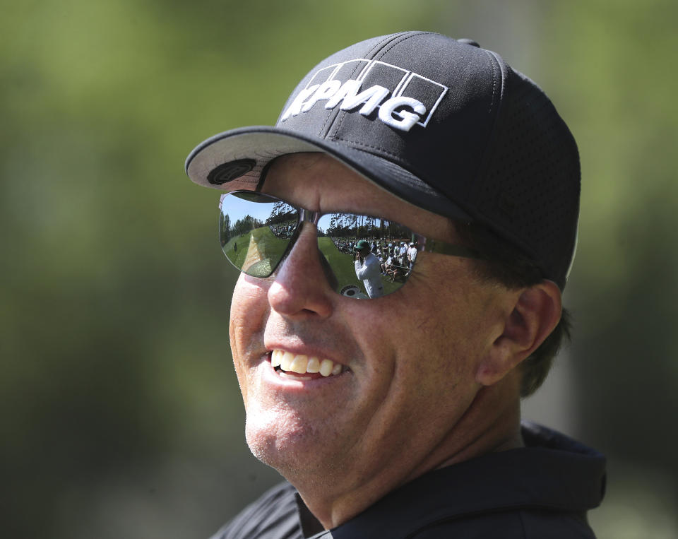 Phil Mickelson is all smiles sharing a laugh with the patrons while he tees off on the 14th hole during his practice round for the Masters at Augusta National Golf Club on Tuesday, April 6, 2021, in Augusta, Ga. (Curtis Compton/Atlanta Journal-Constitution via AP)