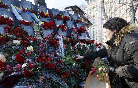 A woman places flowers at the monument of the so-called "Nebesna Sotnya" (Heavenly Hundred), the anti-government protesters killed during the Ukrainian pro-European Union (EU) mass protests in 2014, during a rally commemorating the third anniversary of protests, in central Kiev, Ukraine February 20, 2017. REUTERS/Valentyn Ogirenko