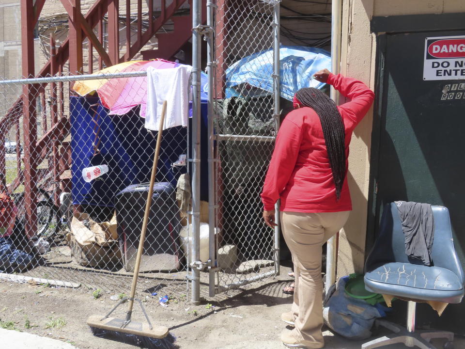 An outreach worker talks to a homeless woman ensconced in a makeshift shelter she erected behind an apartment in Atlantic City, N.J., on Monday, July 1, 2024. The city is launching programs to address homelessness in the seaside gambling resort. (AP Photo/Wayne Parry)
