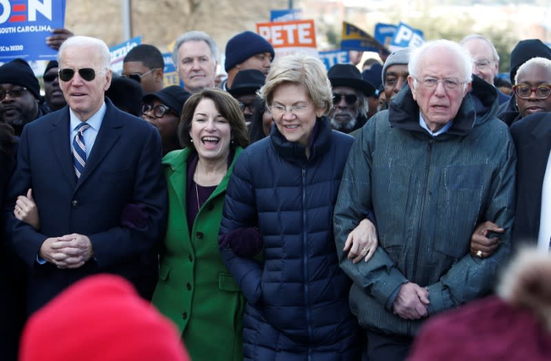 Seven of the Democratic US Presidential candidates walk arm-in-arm with local African-American leaders during the Martin Luther King Jr. (MLK) Day Parade in Columbia