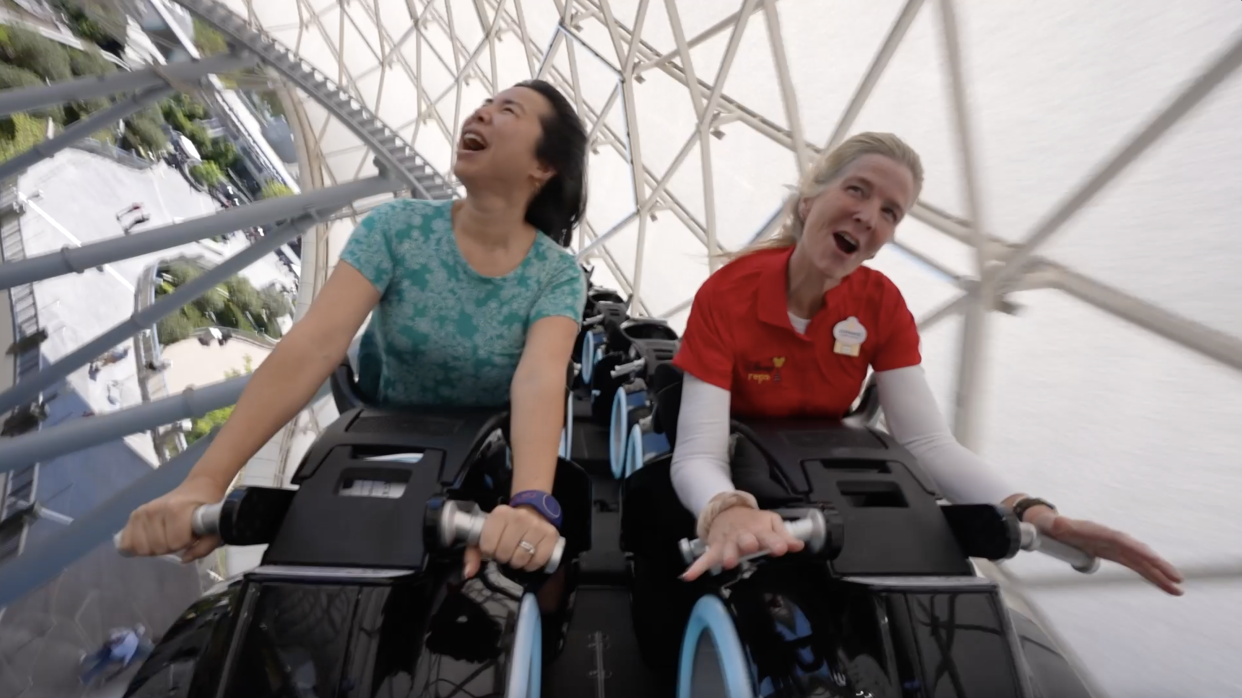 USA TODAY reporter Eve Chen, left, found lifting her torso up with her arms straight was the most comfortable position on TRON Lightcycle / Run.