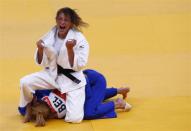 Brazil's Sarah Menezes celebrates after defeating Belgium's Charline van Snick (blue) in their women's -48kg semi-final of table B judo match, at the London 2012 Olympic Games July 28, 2012.