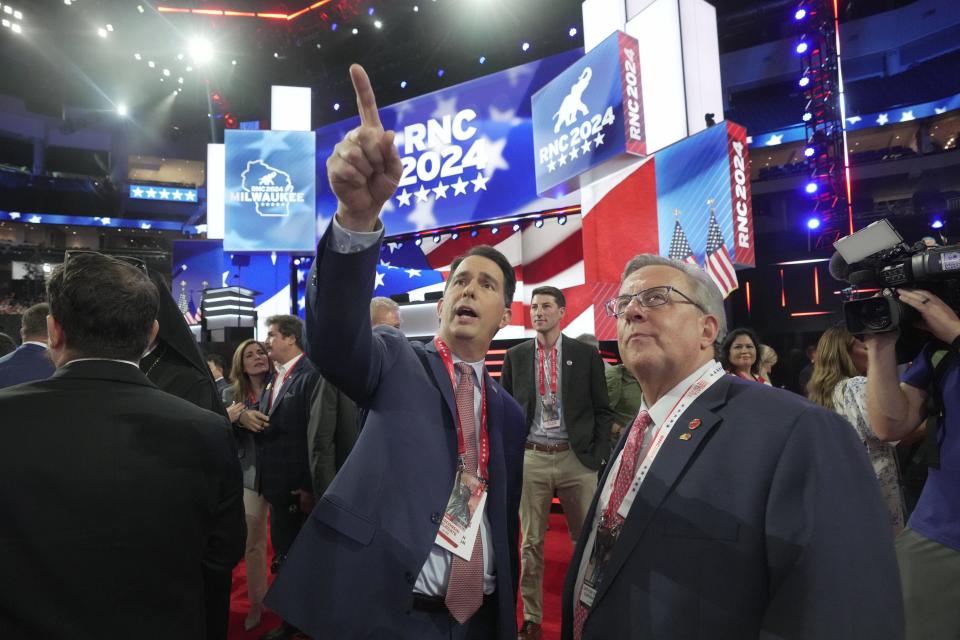Former Wisconsin Gov. Scott Walker, left, and Wisconsin Chairman Brian Schimming, right, on the floor of the Fiserv Forum during the first day of the Republican National Convention. The RNC kicked off the first day of the convention with the roll call vote of the states.