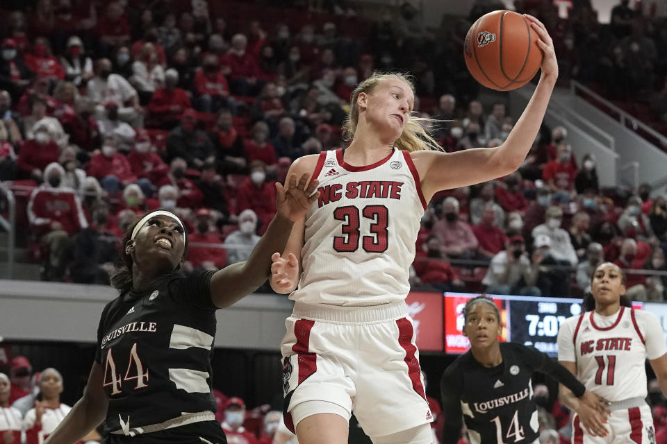 North Carolina State center Elissa Cunane (33) grabs a rebound over Louisville forward Olivia Cochran (44) during the second half of an NCAA college basketball game in Raleigh, N.C., Thursday, Jan. 20, 2022. (AP Photo/Gerry Broome)