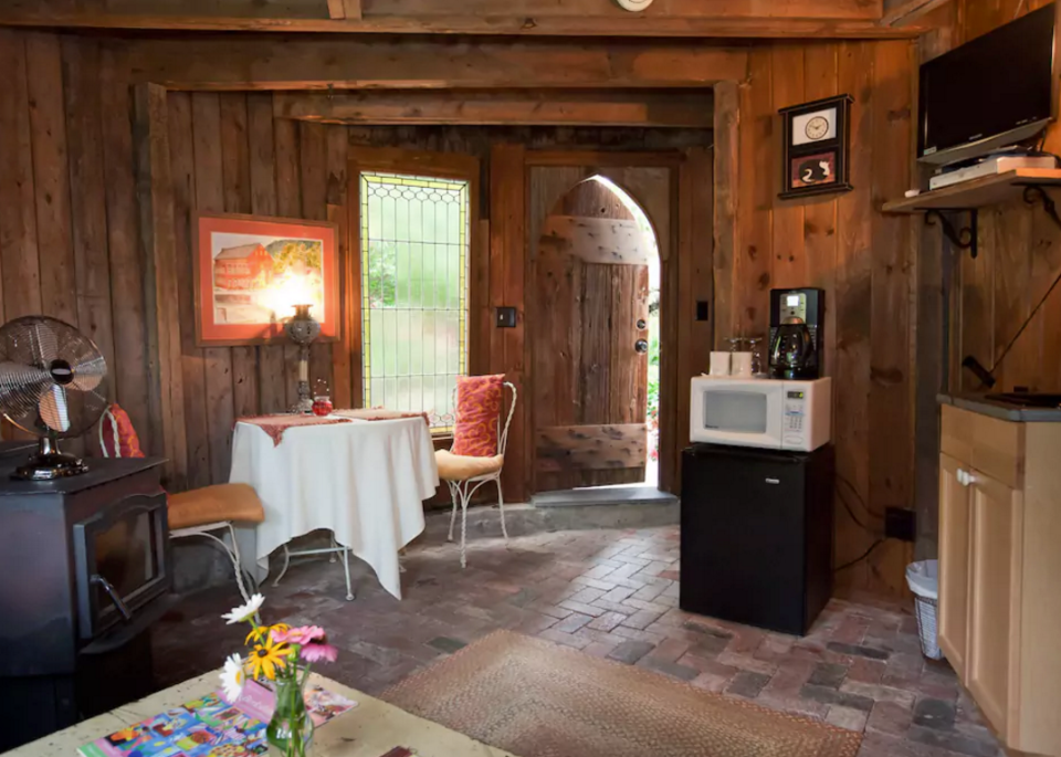 <p>The sitting room has a beautiful wood interior and stone floors. (Airbnb) </p>