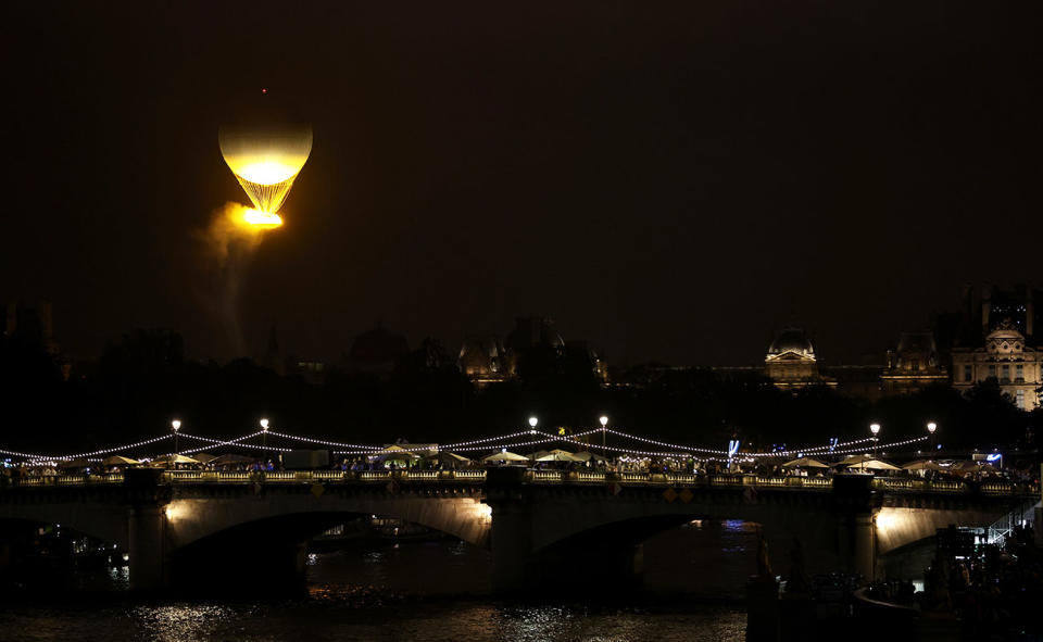 The Olympic cauldron, pictured here flying through the Paris sky.