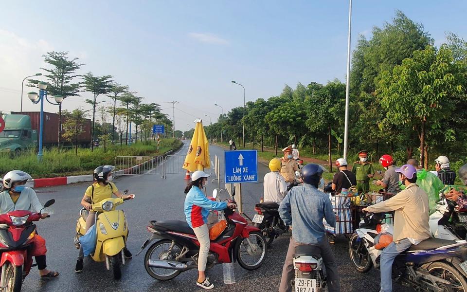 People are turned away at a checkpoint at an entrance to Hanoi - AP