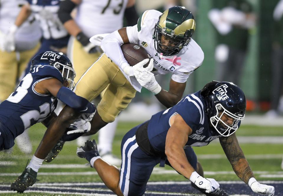 Colorado State wide receiver Tory Horton, top right, is tackled by Utah State cornerback Ja’kheo Mitchell (23) and linebacker MJ Tafisi Jr. (2). | Eli Lucero/The Herald Journal via AP