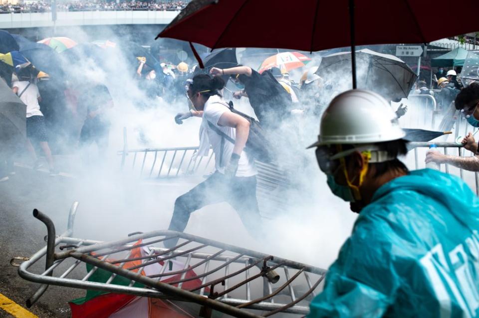 Protesters run after police fired tear gas during a rally against a controversial extradition law proposal outside the government headquarters in Hong Kong on June 12, 2019. | Philip Fong—AFP/Getty Images