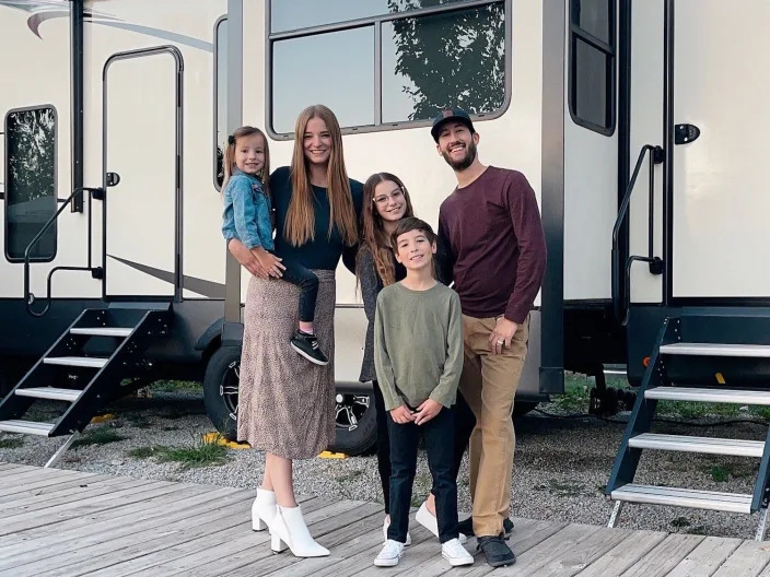 The family in front of the RV.