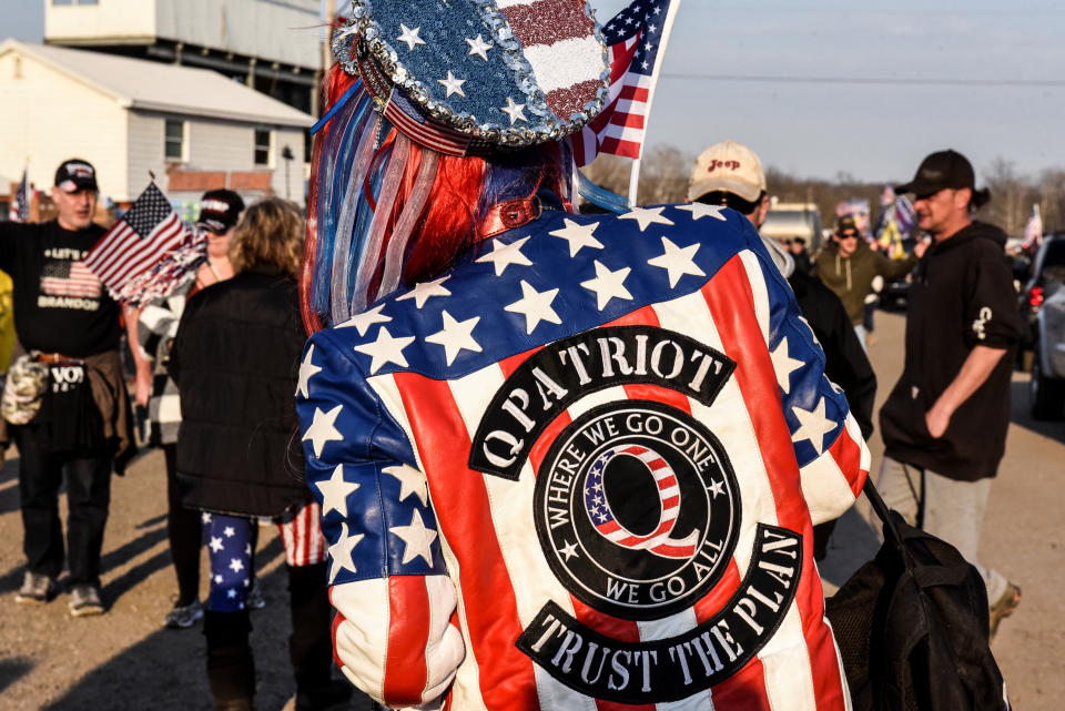 A woman wears a jacket with a QAnon logo at a rally in Hagerstown, Md., in March 2022.