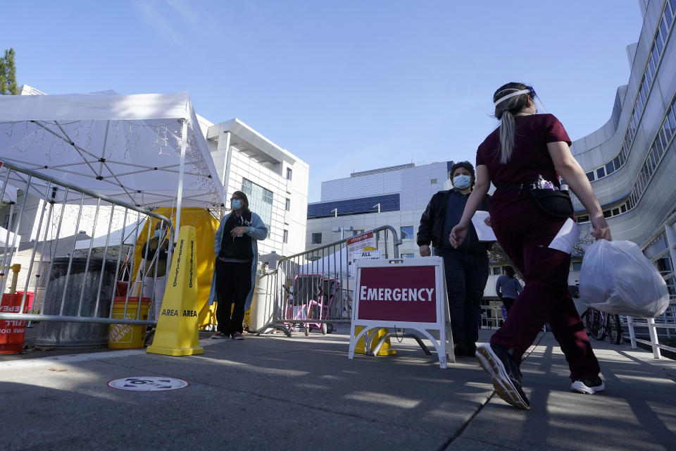 People walk outside of Santa Clara Valley Medical Center during the coronavirus pandemic in San Jose, Calif., Wednesday, Jan. 13, 2021. (AP Photo/Jeff Chiu)
