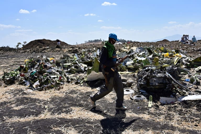 A man walks by a pile of twisted debris at the crash site of an Ethiopian Airways Boeing 737 MAX in March 2019 (TONY KARUMBA)