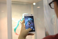 An anime lover taking a picture of an anime character figurine. (Photo: Sharlene Sankaran/Yahoo Singapore)