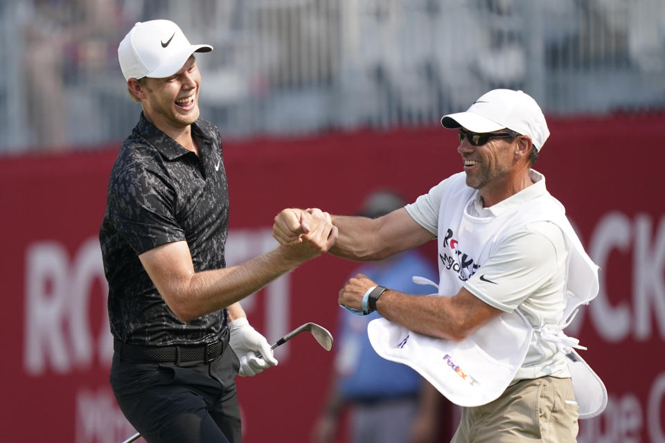 Cam Davis of Australia jubilates with his caddie after scoring an eagle on the 17th green from the sand during the final round of the Rocket Mortgage Classic golf tournament, Sunday, July 4, 2021, at the Detroit Golf Club in Detroit. (AP Photo/Carlos Osorio)