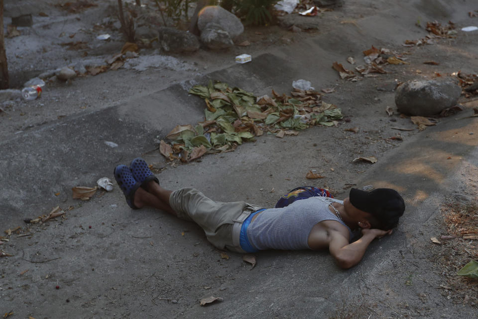 Un migrante centroamericano que viaja en una caravana a la frontera con Estados Unidos descansa en la carretera cerca de Pijijiapan, México, el lunes 22 de abril de 2019. (AP Foto / Moisés Castillo)